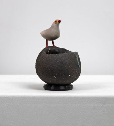 grey bird on black nest by Chris Barnes